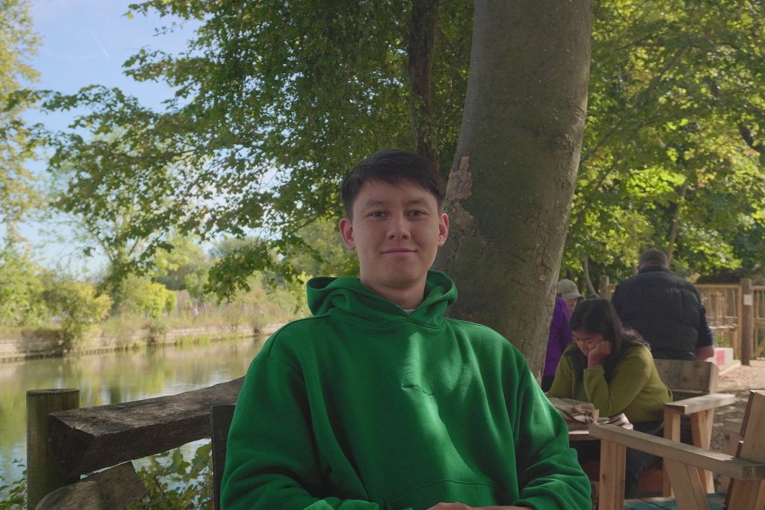 John sitting beside a river beneath a tree